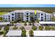 Condo building with a white exterior, parking, palm trees, and landscape at 14051 Heritage Landing Blvd # 536, Punta Gorda, FL 33955