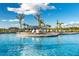 Resort-style pool featuring a sun deck with plenty of lounge chairs, a covered lounge, and swaying palms at 14051 Heritage Landing Blvd # 536, Punta Gorda, FL 33955