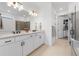 Bright bathroom has dual sinks, tile flooring, and a glass-enclosed shower at 15830 Appalachian Dr, Punta Gorda, FL 33982