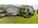 A lovely home featuring an attached two-car garage, beautiful landscaping with mature palm trees and a well-maintained lawn at 15830 Appalachian Dr, Punta Gorda, FL 33982