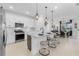 Modern kitchen featuring white cabinets, a large island, stainless steel appliances, and stylish pendant lighting at 15830 Appalachian Dr, Punta Gorda, FL 33982