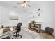 Bright home office with a modern glass desk, shelves, and a comfortable seating area at 15830 Appalachian Dr, Punta Gorda, FL 33982