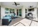Inviting covered patio featuring comfortable seating, ceiling fans, brick pavers, and an outdoor grill at 15830 Appalachian Dr, Punta Gorda, FL 33982