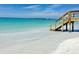 Picturesque beach scene with a wooden walkway leading to the crystal-clear turquoise water at 16031 Quinta Dr, Punta Gorda, FL 33955