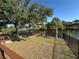 Beautiful backyard with mature trees, lush landscaping, and a private wooden dock by the water at 17356 Gulfspray Cir, Port Charlotte, FL 33948