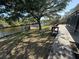 Scenic waterfront backyard featuring a private dock, mature trees, and a concrete patio at 17356 Gulfspray Cir, Port Charlotte, FL 33948
