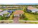Aerial view of a home featuring a tile roof, well-maintained landscaping, and a tranquil pond in the neighborhood at 1745 Hyssop Loop, North Port, FL 34289