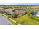 Aerial view of a home featuring a tile roof, well-maintained landscaping, and a tranquil pond in the neighborhood at 1745 Hyssop Loop, North Port, FL 34289