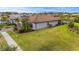 Aerial view of a home featuring a tile roof, well-maintained landscaping, and a tranquil pond in the neighborhood at 1745 Hyssop Loop, North Port, FL 34289