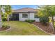 Landscaped backyard with a screened-in lanai, well-kept lawn and mulch beds at 1745 Hyssop Loop, North Port, FL 34289