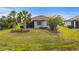 Well-manicured lawn with palms and manicured landscaping surrounding a screened in lanai at 1745 Hyssop Loop, North Port, FL 34289