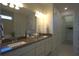 Elegant bathroom with double sinks, a large mirror, and a walk-in closet at 1745 Hyssop Loop, North Port, FL 34289