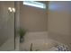 The bright bathroom features a soaking tub beneath a window, complemented by elegant tile and decor at 1745 Hyssop Loop, North Port, FL 34289