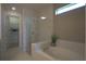 Bright bathroom featuring a soaking tub, glass enclosed shower, and walk-in closet at 1745 Hyssop Loop, North Port, FL 34289