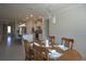 Dining room with view of kitchen features wood table and chairs with decorative chandelier at 1745 Hyssop Loop, North Port, FL 34289