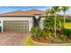 Charming single-story home featuring a well-manicured lawn, beautiful landscaping, and brick driveway at 1745 Hyssop Loop, North Port, FL 34289