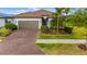 Charming single-story home featuring a brick driveway, well-manicured landscaping, and a neutral color scheme at 1745 Hyssop Loop, North Port, FL 34289