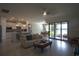 Bright open-plan living space with tile floors seamlessly transitions into a modern kitchen and dining area at 1745 Hyssop Loop, North Port, FL 34289