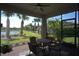Screened-in patio featuring brick flooring, comfortable seating, ceiling fan, and a beautiful view of the backyard at 1745 Hyssop Loop, North Port, FL 34289