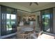 Covered patio with seating and views of the lake and kitchen, with access through sliding glass doors at 1745 Hyssop Loop, North Port, FL 34289