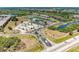 An aerial view of the community entrance, ponds, condo buildings, and surrounding wooded areas at 175 Kings Hwy # 1114, Punta Gorda, FL 33983