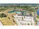 A beautiful aerial view of the community including a pool, tennis courts, lake, and nearby condos at 175 Kings Hwy # 1114, Punta Gorda, FL 33983