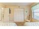 Bright bedroom with white closet doors, chair, and window with patterned curtain at 175 Kings Hwy # 1114, Punta Gorda, FL 33983