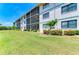 Well-maintained building exterior with screened balconies and lush landscaping at 175 Kings Hwy # 1114, Punta Gorda, FL 33983