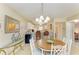 Dining room with round wood table, seating for four, and modern chandelier at 175 Kings Hwy # 1114, Punta Gorda, FL 33983