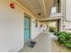Exterior condo entrance with a teal door, nautical decor, and neat landscaping for a welcoming arrival at 175 Kings Hwy # 1114, Punta Gorda, FL 33983