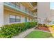 A ground-level view of the exterior of the condo building showcasing landscaping and walkways at 175 Kings Hwy # 1114, Punta Gorda, FL 33983