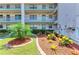 Exterior building view features well maintained landscaping and colorful plants by the condo units at 175 Kings Hwy # 1114, Punta Gorda, FL 33983