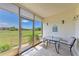 Enclosed patio has a table and chairs and a serene view of the green at 175 Kings Hwy # 1114, Punta Gorda, FL 33983