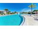 Community pool with lush palm trees and lounge seating surrounding it for relaxation and enjoyment at 175 Kings Hwy # 1114, Punta Gorda, FL 33983