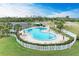 Aerial view of community pool with surrounding lounge chairs and tennis courts in the background at 175 Kings Hwy # 1114, Punta Gorda, FL 33983