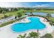 Aerial view of a community pool surrounded by lush landscaping, with pond and golf course views at 175 Kings Hwy # 1114, Punta Gorda, FL 33983