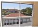 Screened-in balcony view of neighboring buildings with tile roofs and lush green trees at 18001 Richmond Place Dr # 636, Tampa, FL 33647