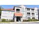 Exterior view of condo building with gray facade, red tile roof, and well-maintained landscaping at 18001 Richmond Place Dr # 636, Tampa, FL 33647