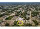 Aerial view of a neighborhood featuring a home with a screened in pool, surrounded by lush greenery at 21080 Firwood Ter, Port Charlotte, FL 33954