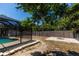 Outdoor space with a fenced yard with the pool area, lush trees, and a cozy fire pit at 21080 Firwood Ter, Port Charlotte, FL 33954