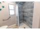 Renovated bathroom featuring tiled walk-in shower with grab bar and a window at 21080 Firwood Ter, Port Charlotte, FL 33954