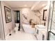 Modern bathroom featuring marble wall accents, a standalone tub, and dual vanity sinks at 21080 Firwood Ter, Port Charlotte, FL 33954