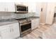 Modern kitchen boasts stainless steel appliances, granite countertops, and white cabinets at 21080 Firwood Ter, Port Charlotte, FL 33954