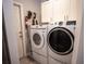 Laundry room featuring side-by-side washer and dryer with white cabinets above at 21080 Firwood Ter, Port Charlotte, FL 33954