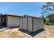 A storage shed in the backyard with a stone paver base, situated next to the house at 21080 Firwood Ter, Port Charlotte, FL 33954