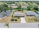 Aerial view of a well-maintained home featuring a large yard, mature trees and a concrete driveway at 218 Parkview Dr, Venice, FL 34293