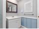 Bathroom featuring a modern vanity, mirror, and charming blue-striped wallpaper-style wall treatment at 218 Parkview Dr, Venice, FL 34293
