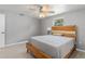 Light-filled bedroom with wood-look flooring, gray walls, and a ceiling fan and light fixture at 218 Parkview Dr, Venice, FL 34293