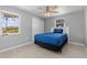 This bedroom is bright with two windows and modern ceiling fan with blue bedding at 218 Parkview Dr, Venice, FL 34293