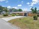Charming single-story home with a well-manicured lawn, mature trees and concrete driveway at 218 Parkview Dr, Venice, FL 34293